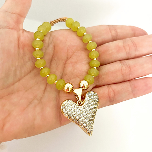 Adjustable olive green bracelet with a large pavé heart charm and gold-tone details, designed to add a touch of glamour.