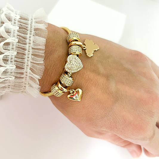 Elegant gold bracelet featuring rhinestone heart charms and decorative bead accents.