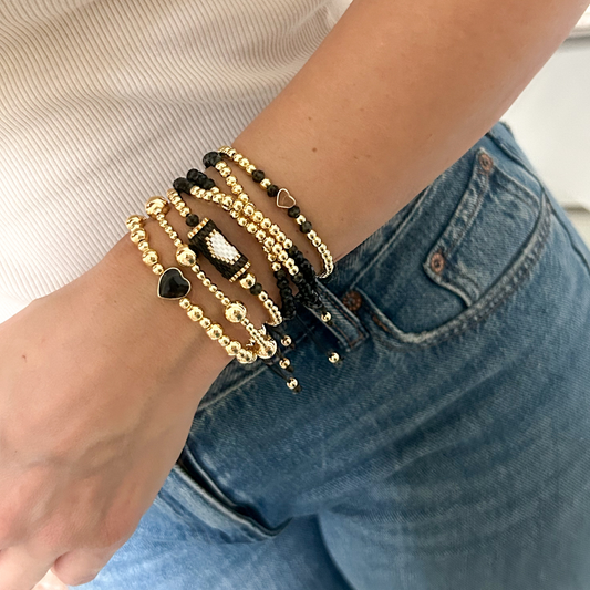Black gold minimal heart bracelet set with miyuki accent worn on wrist