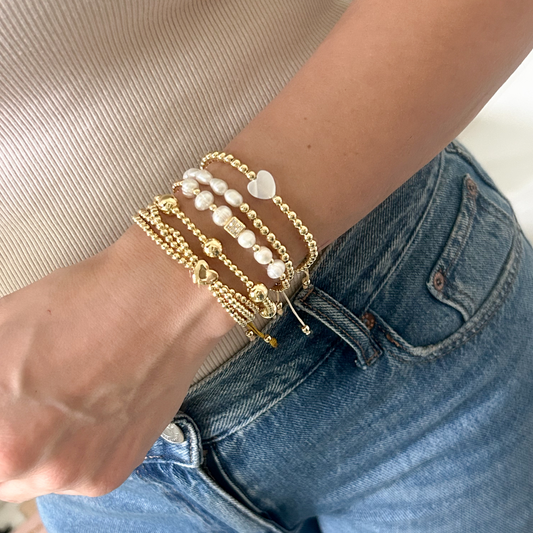 Gold heart pearl bracelet set with pavé charm worn on wrist
