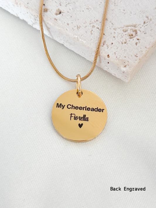 Gold necklace with engraved pendant on a light background
