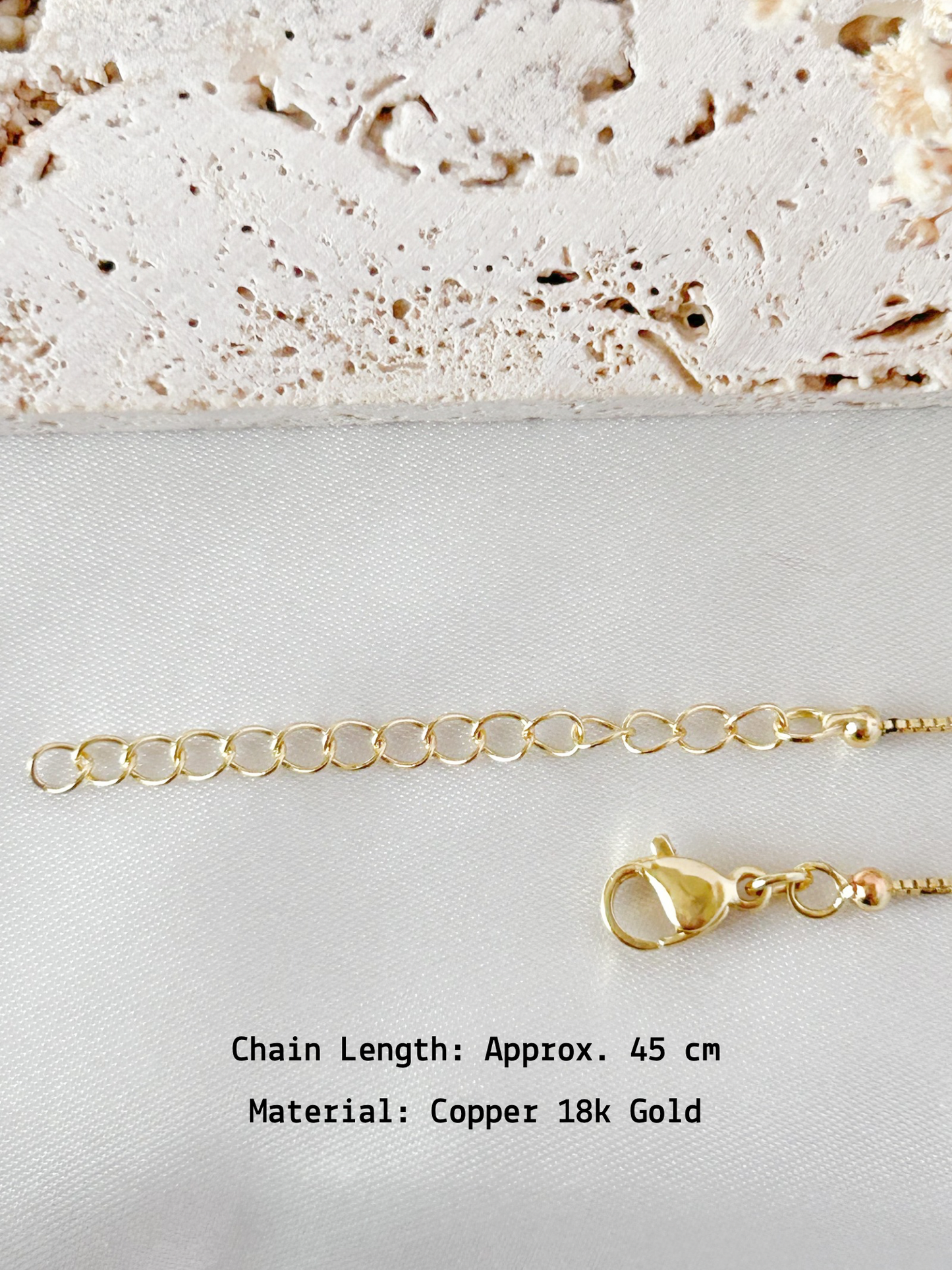 Gold chain with clasp on a textured surface