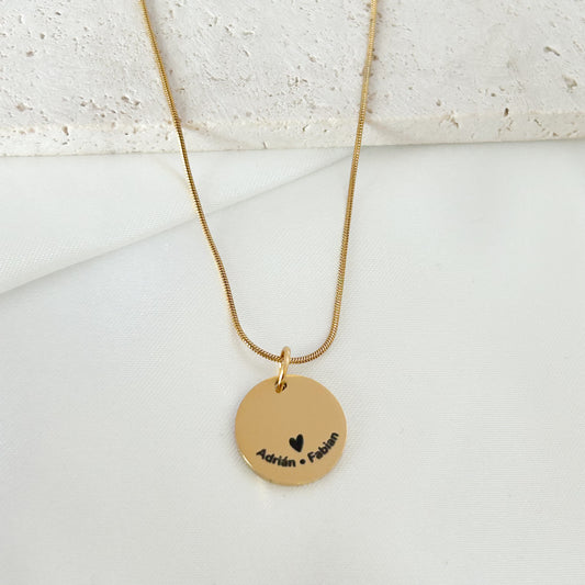 Gold necklace with a round pendant on a light background