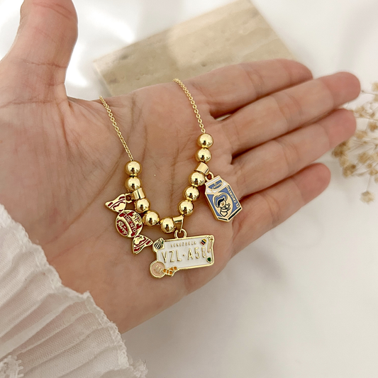 Hand holding Venezuela nostalgia charm necklace to show detail