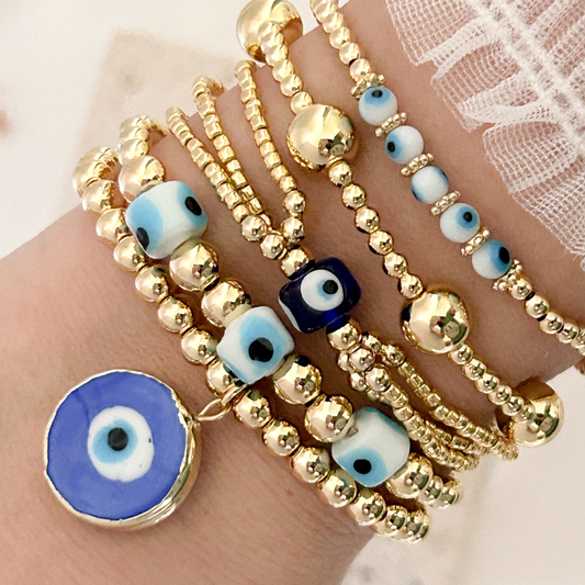Gold beaded bracelet set with blue evil eye charms, minimalist handmade stack jewelry for everyday protection and style