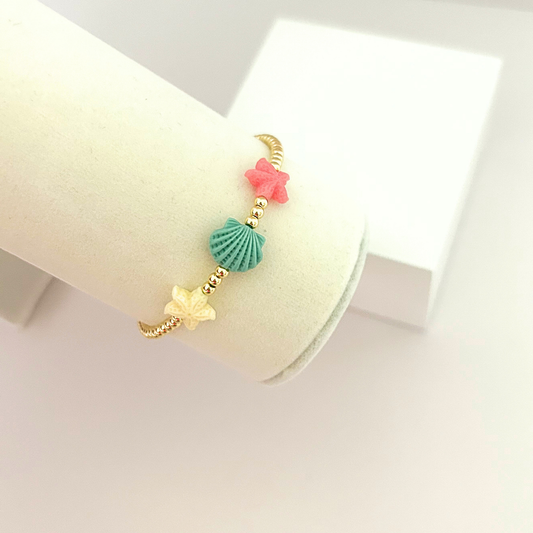 Summer bracelet featuring shell and starfish details with gold-tone beads.