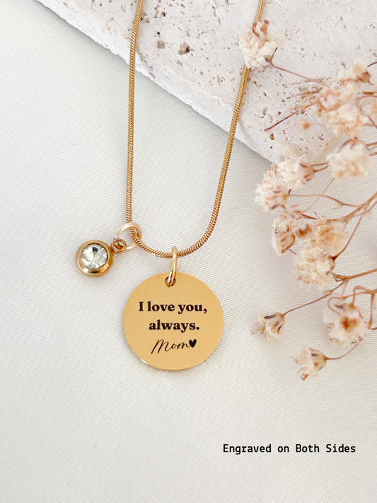 Gold necklace with 'I love you, always. Mom' pendant on a light background