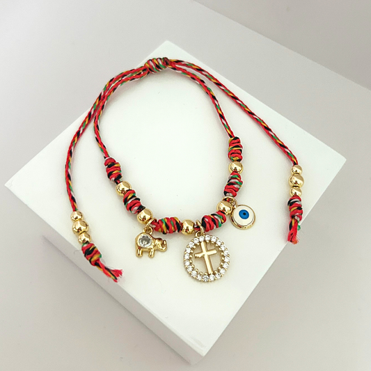 Colorful braided bracelet with cross charm, evil eye pendant and elephant charm.