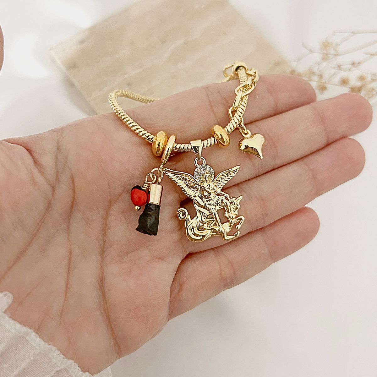 Hand holding Archangel Michael charm bracelet to show size and detail