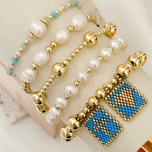 Beaded bracelet with gold and blue accents on a textured surface