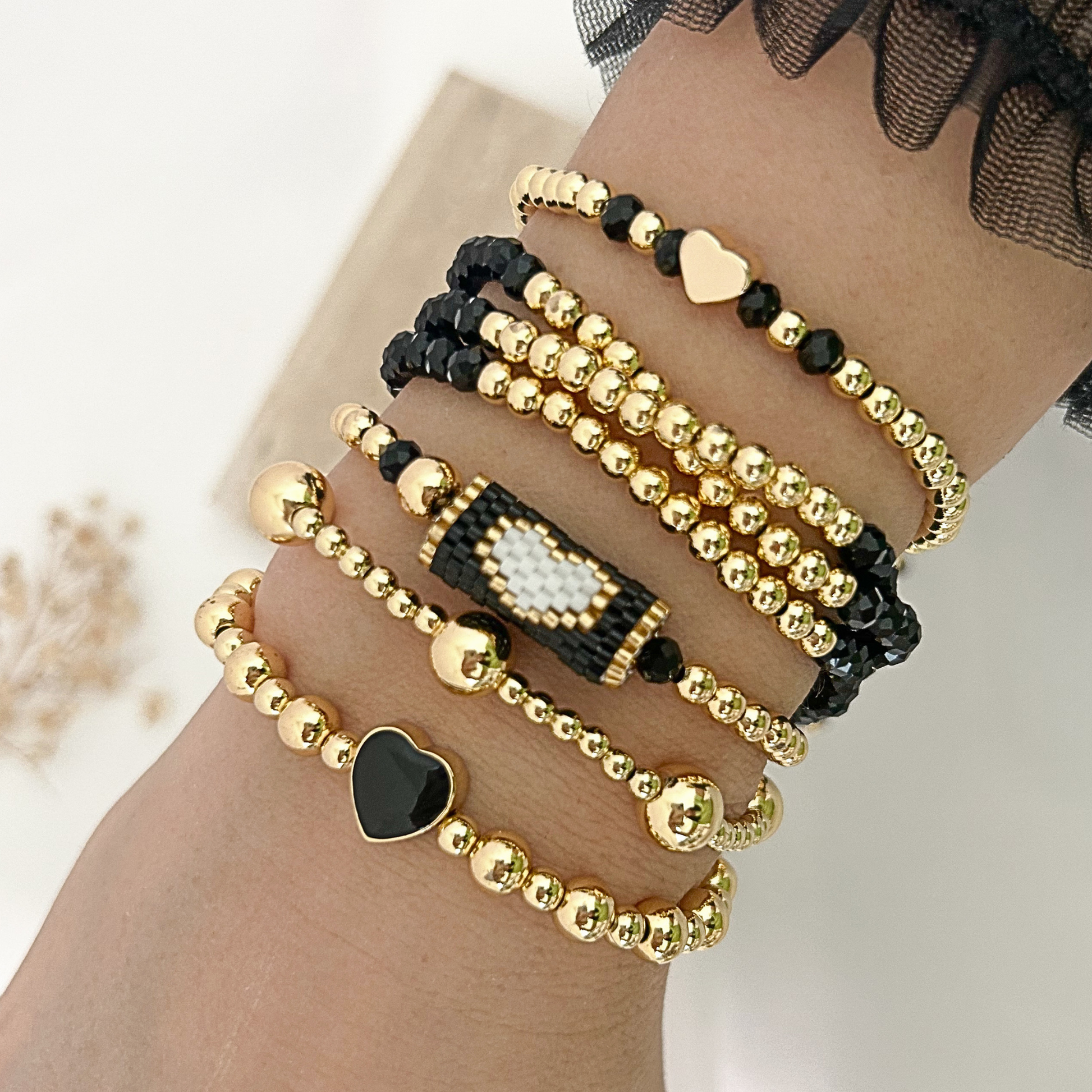 Black gold minimal heart bracelet set with miyuki accent worn on wrist
