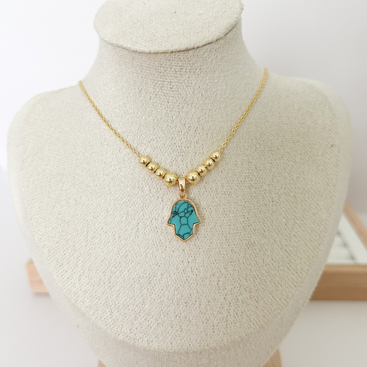Gold beaded necklace with turquoise Hamsa hand pendant on linen jewelry bust — Citrika