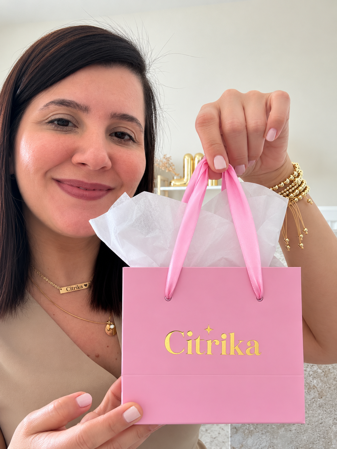 Woman holding a pink 'Citrika' gift bag