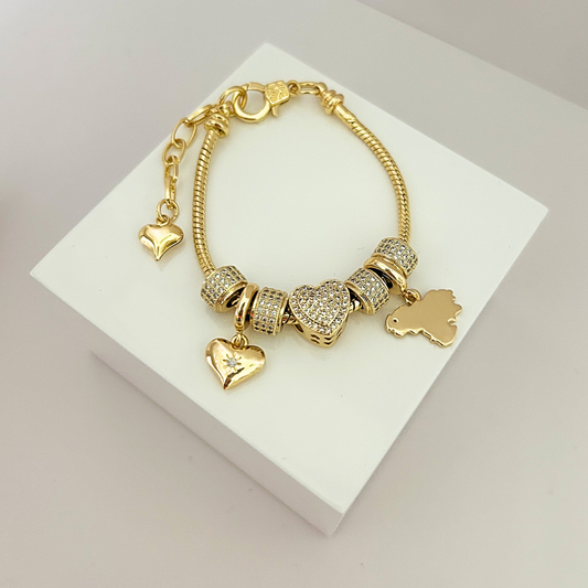 Gold-tone charm bracelet with sparkling heart centerpiece, crystal beads and dangling heart charms.