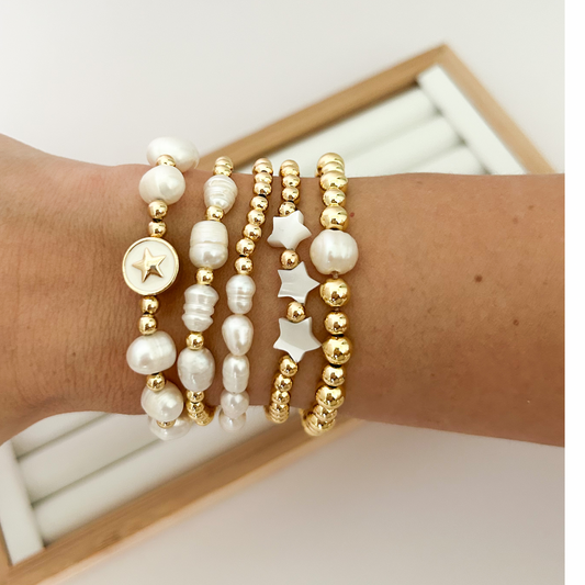 White star pearl bracelet set with gold star medallion worn on wrist