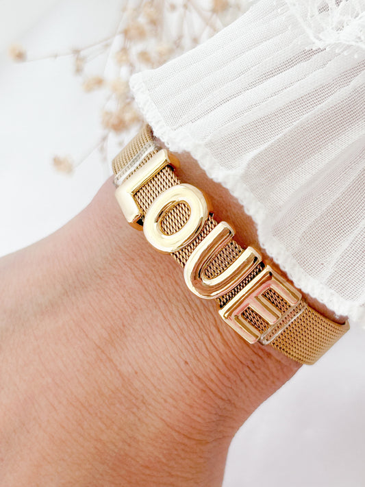 Gold bracelet on a wrist with a blurred background