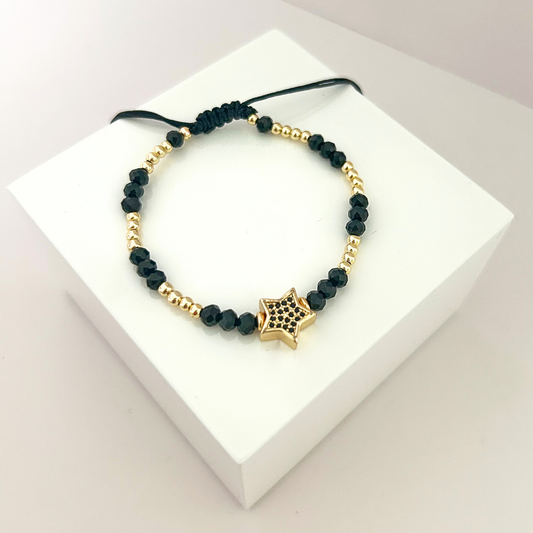 Adjustable black crystal bead bracelet featuring a gold-tone star charm with black crystals, designed with elegant gold accents.
