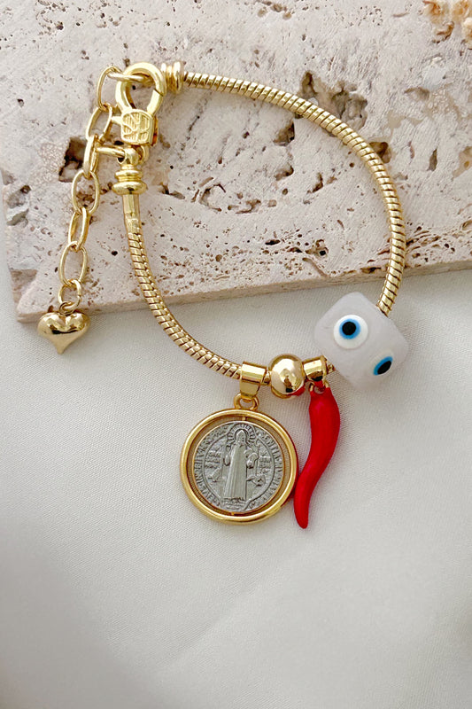 Gold bracelet with charms on a textured surface