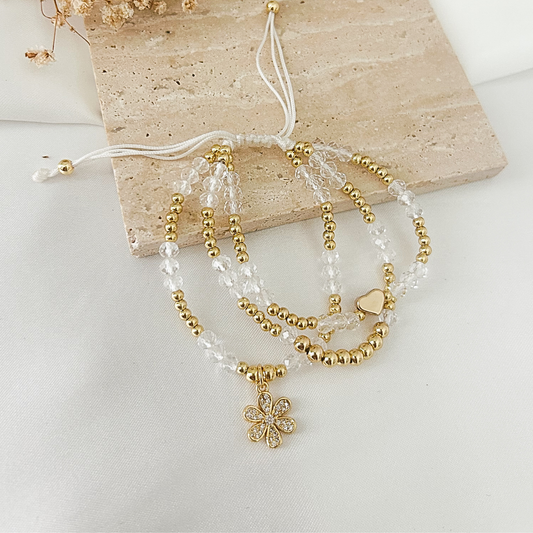 Crystal flower charm bracelet with heart charm on flat surface