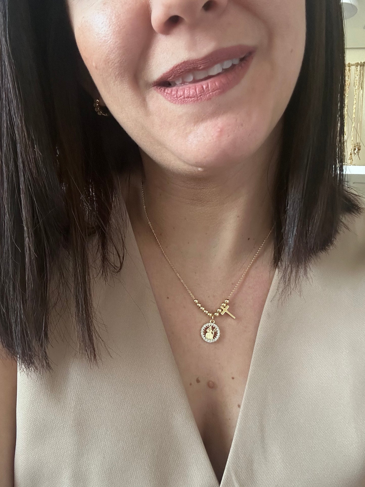 Close-up of a woman wearing a delicate gold necklace with a small pendant.