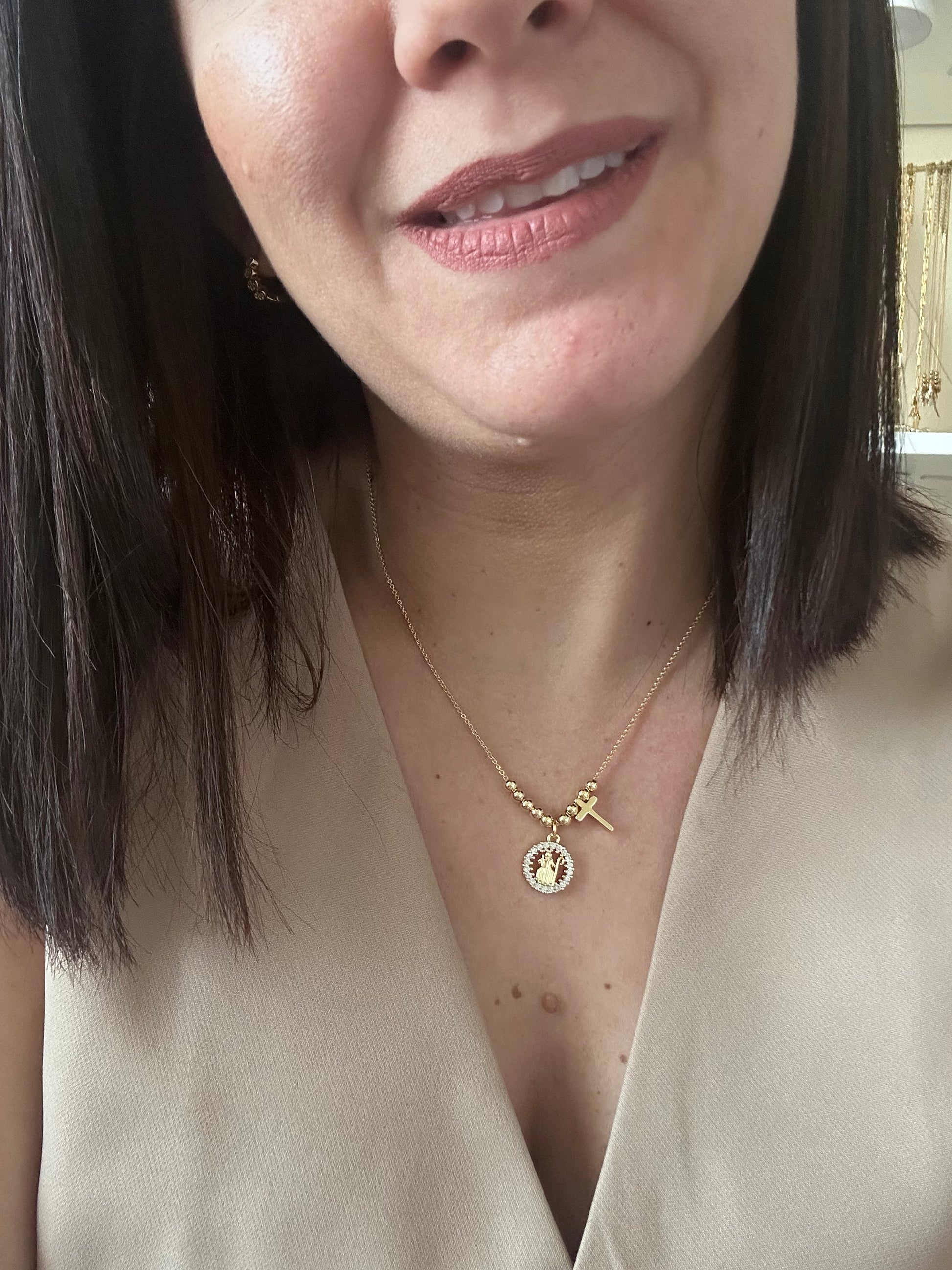 Close-up of a woman wearing a delicate gold necklace with a small pendant.