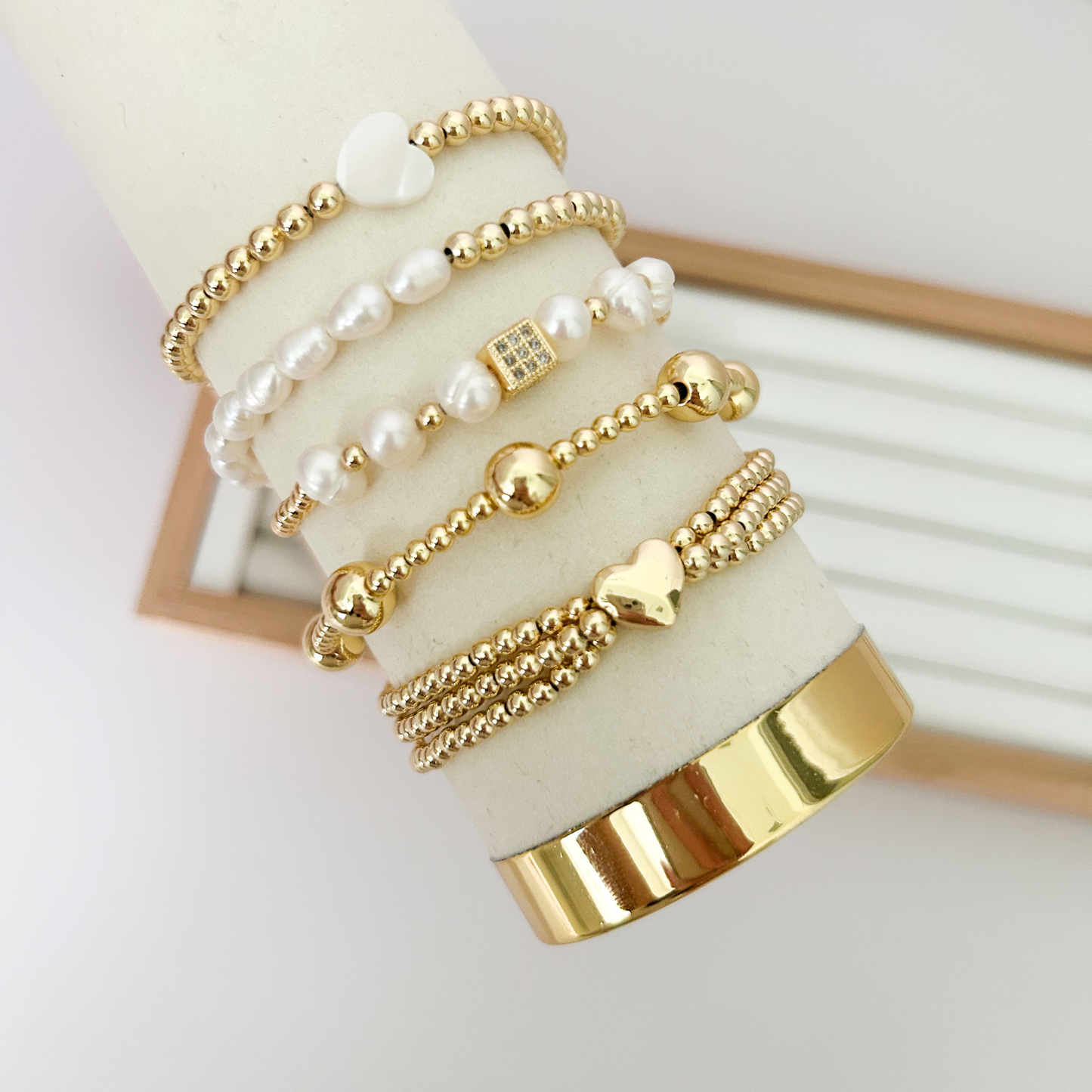 Gold heart pearl bracelet set with pavé square charm on jewelry stand