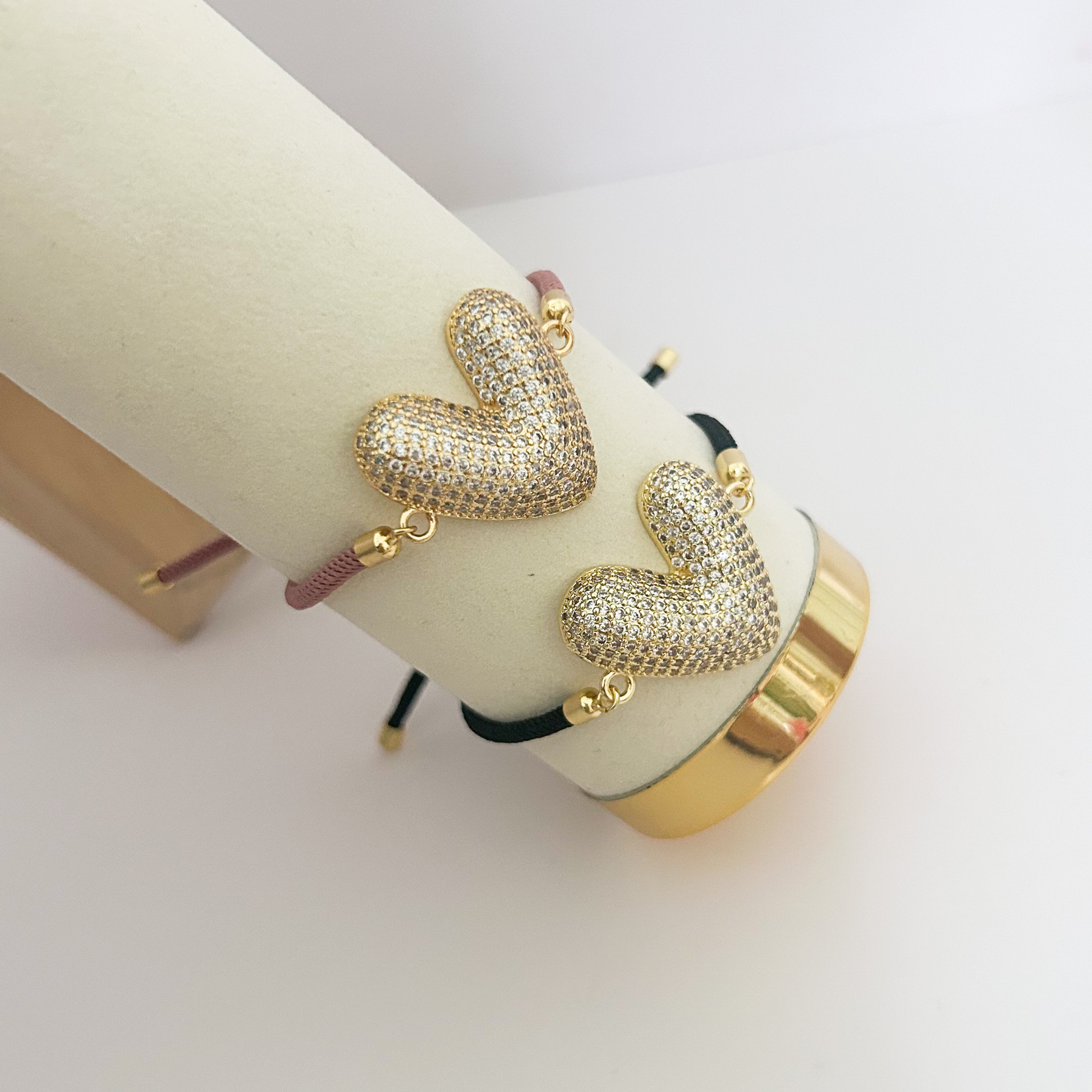 Gold heart bracelet with rhinestone design and adjustable black cord for women.