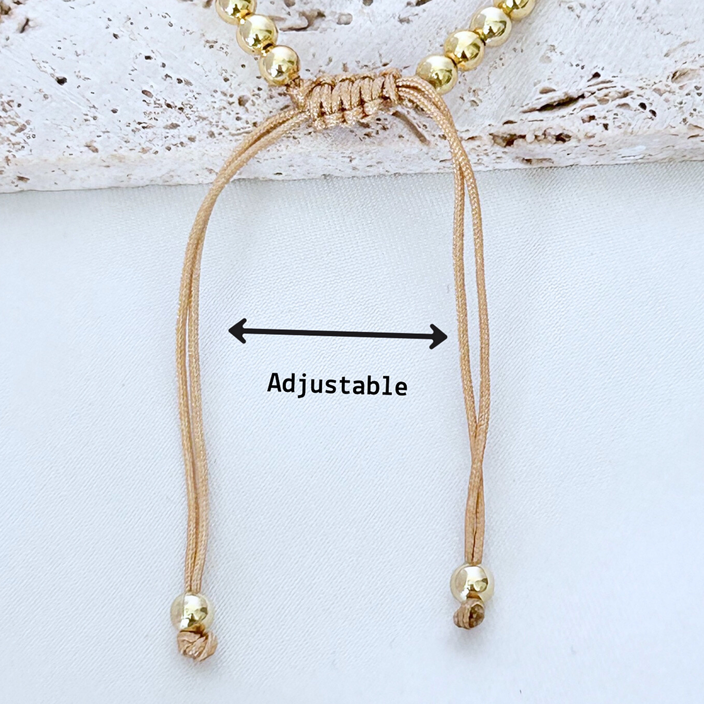 Beaded bracelet with adjustable cord on a light background