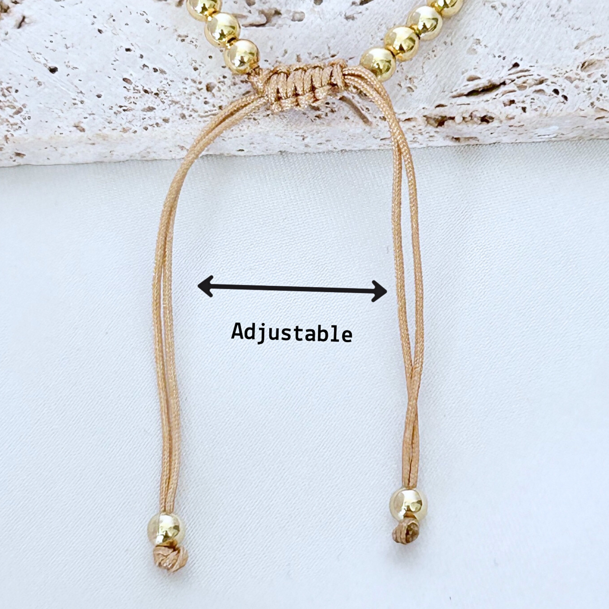 Beaded bracelet with adjustable cord on a light background