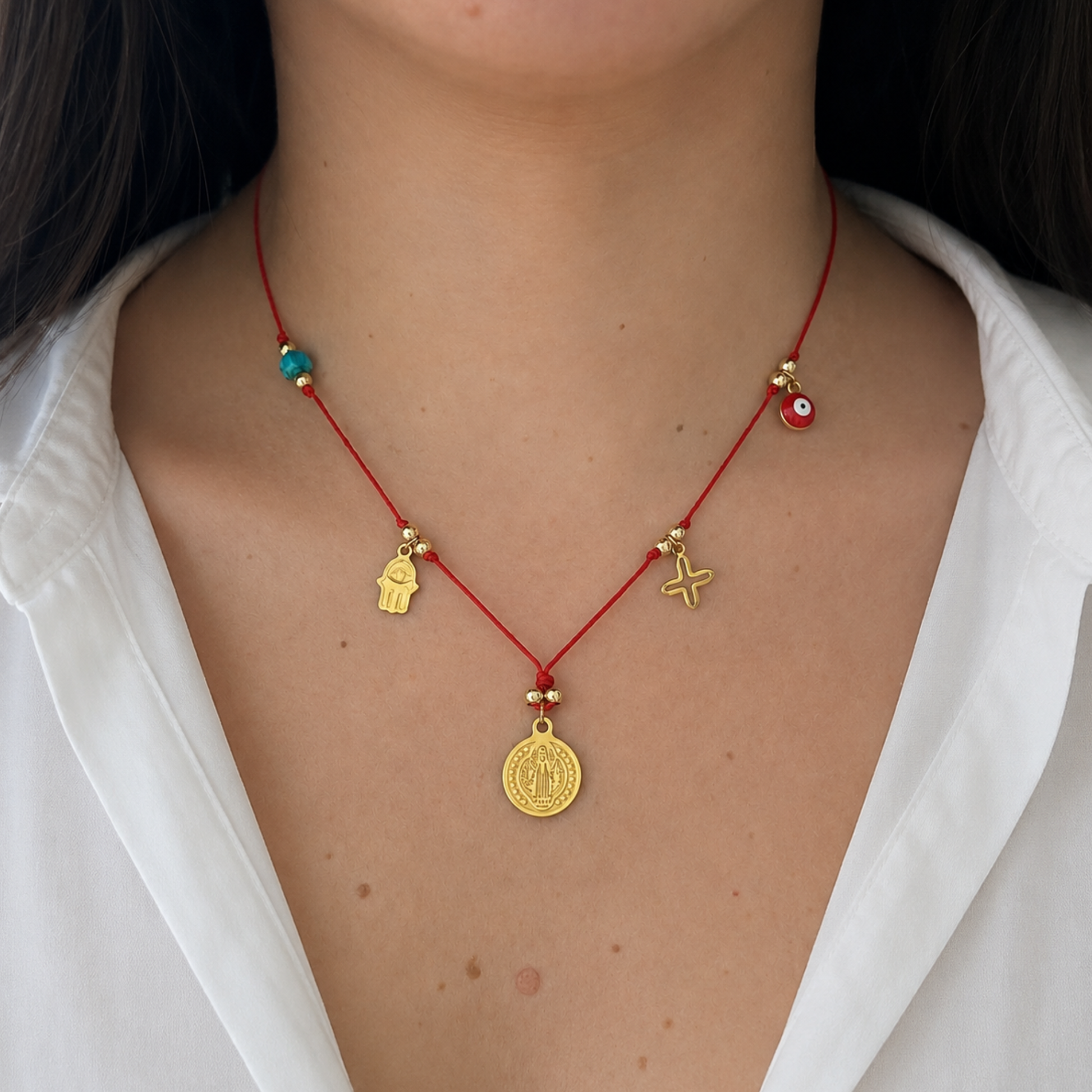 Model wearing a red cord necklace with protective charms and spiritual symbols, creating a meaningful and stylish everyday look.