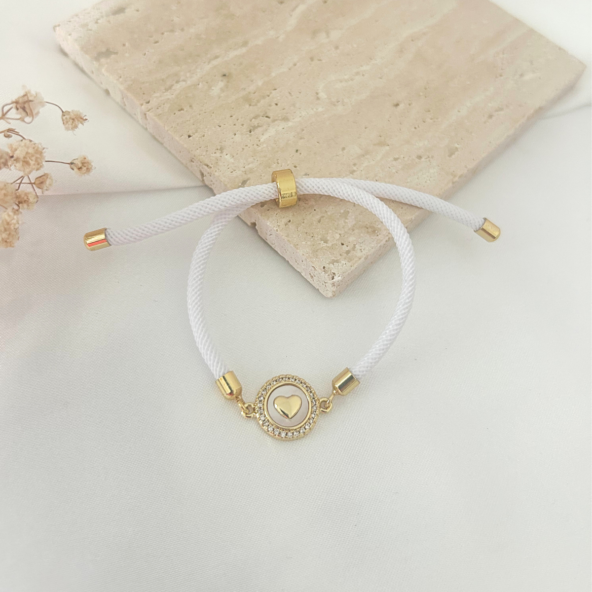 White cord bracelet with heart medallion connector