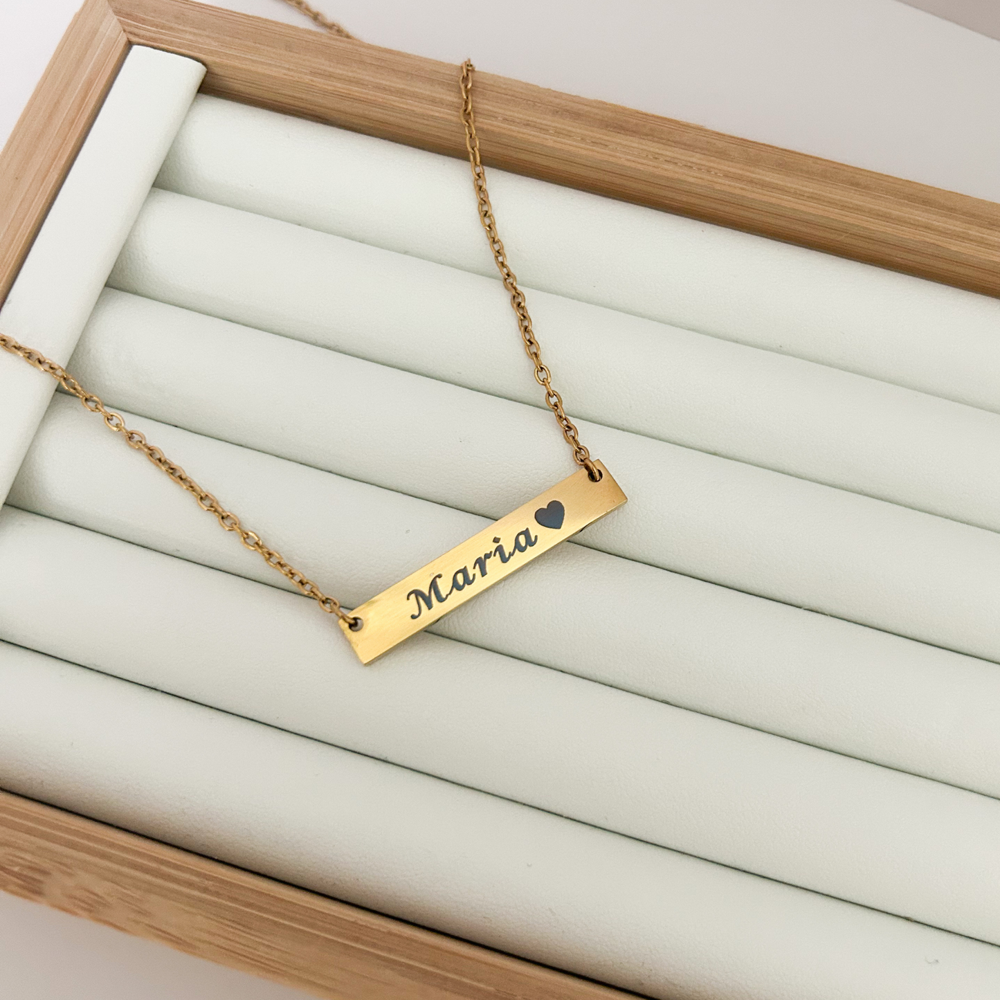 Gold necklace with 'Maria' engraved on a white background