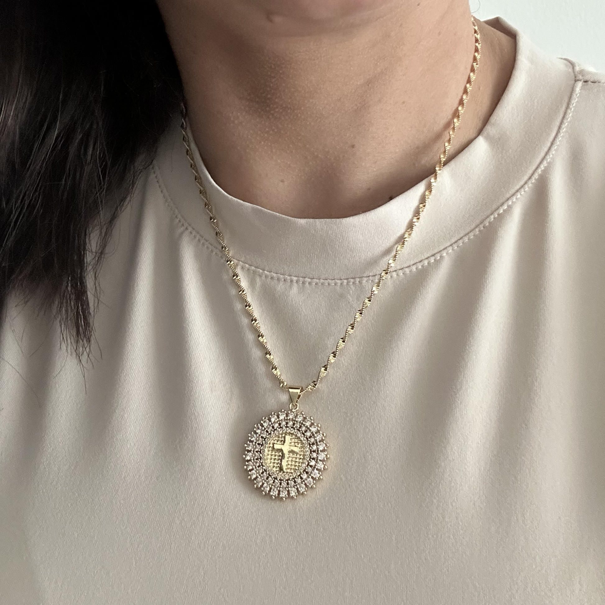Model wearing gold cross medallion necklace for everyday styling.