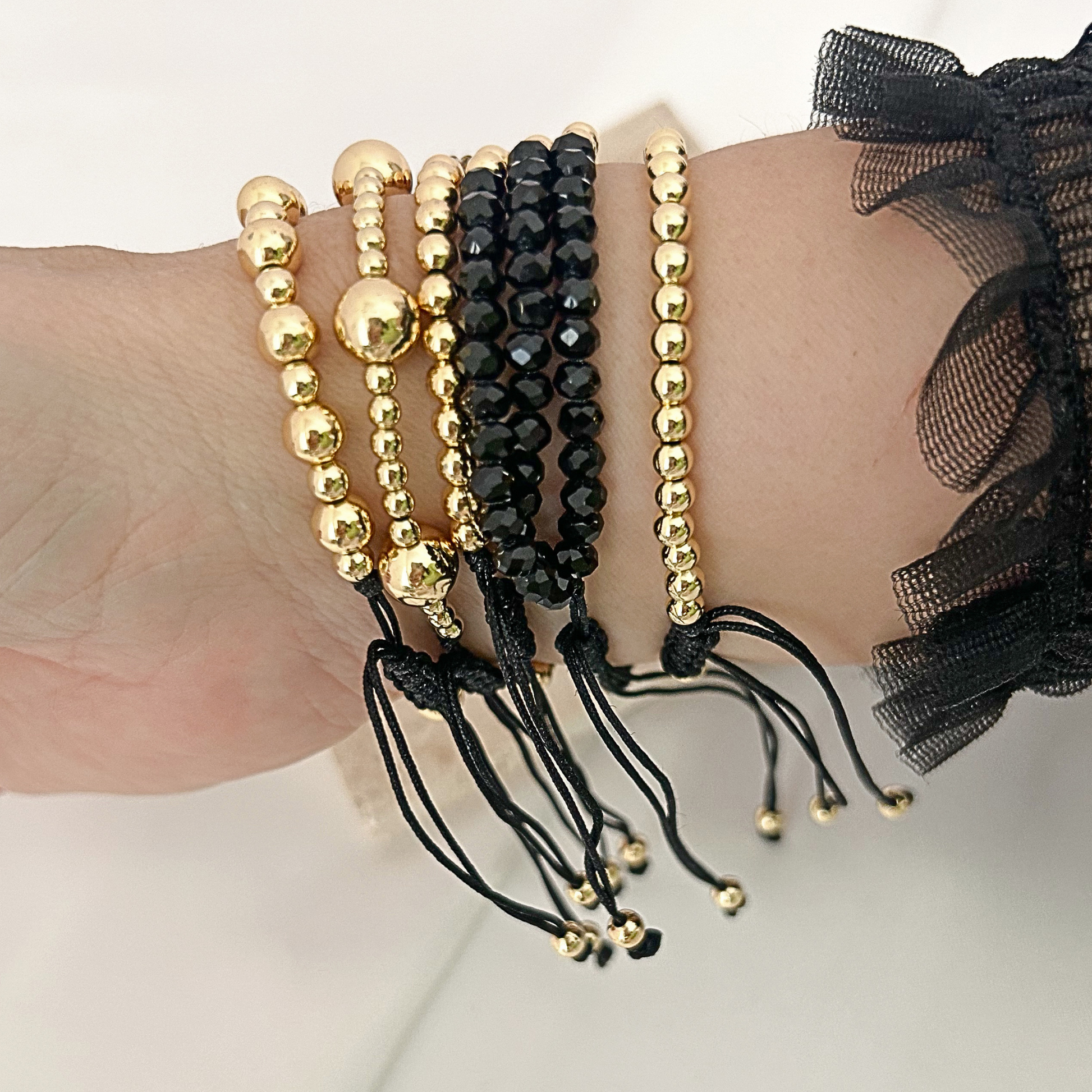 Black gold minimal heart bracelet set with miyuki accent worn on wrist