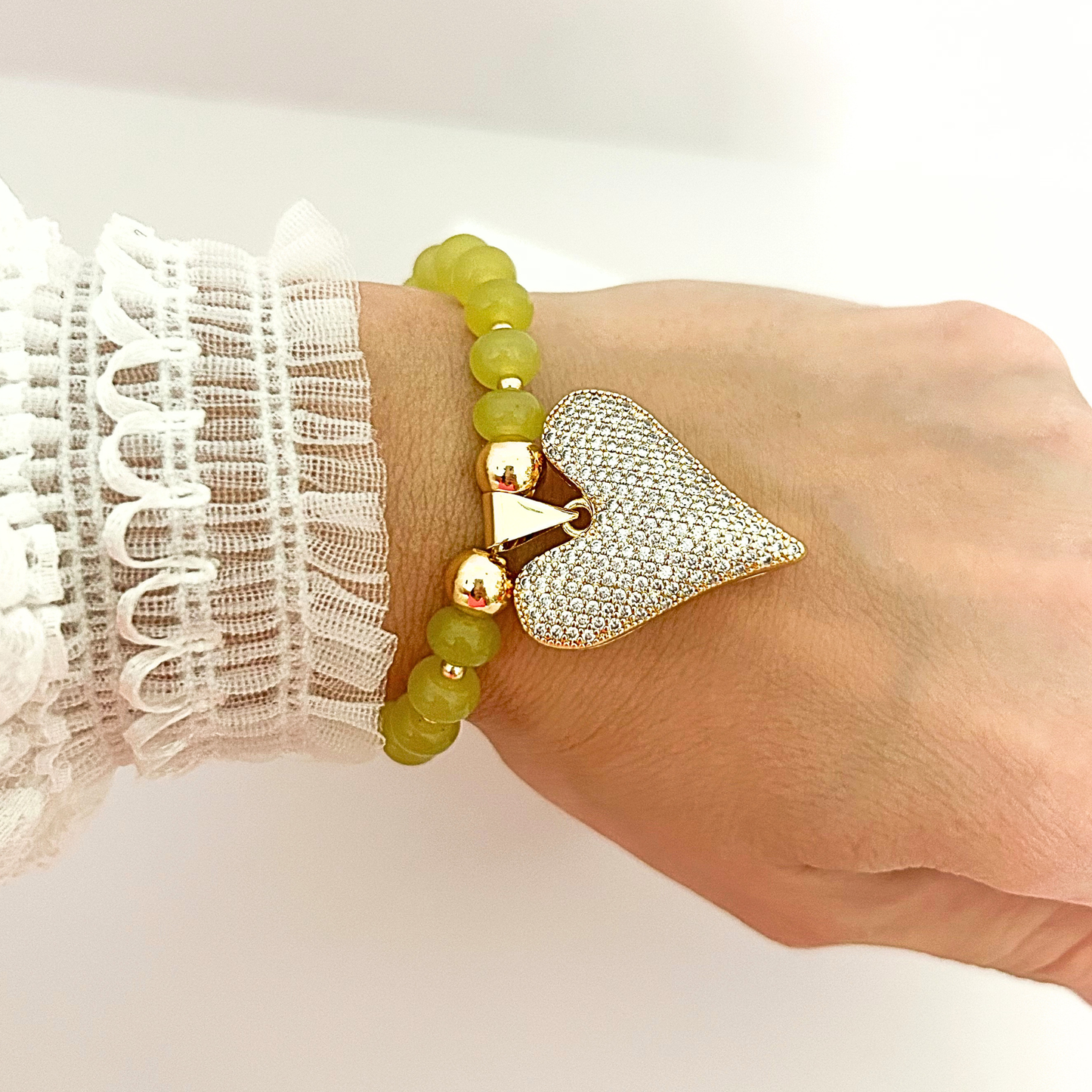 Elegant adjustable bracelet with olive green beads and a dazzling crystal heart pendant, perfect for everyday wear.