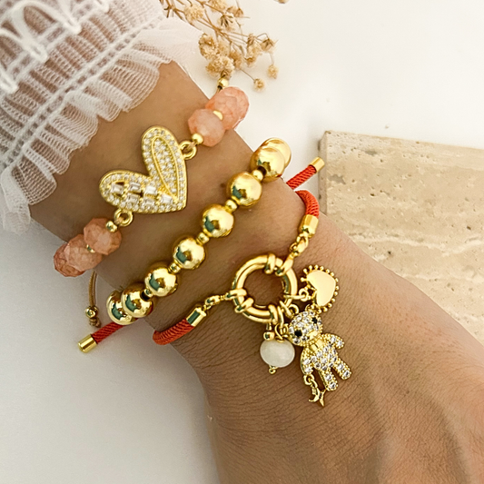 Teddy bear charm bracelet stack with peach crystal and gold bead styles worn on wrist