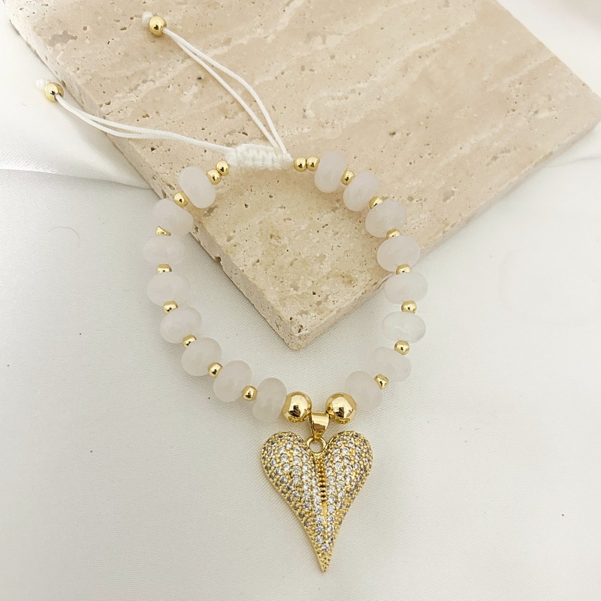 Moonstone bracelet with heart charm on a stone tray