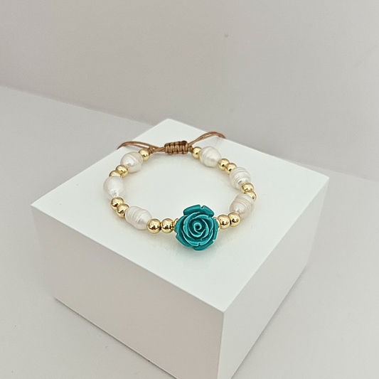 Adjustable bracelet with freshwater pearls, gold-tone beads, and a handcrafted turquoise rose focal piece.