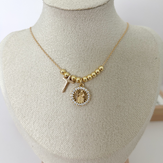 Gold beaded necklace with Divina Pastora medallion and cross charm on linen jewelry bust — Citrika
