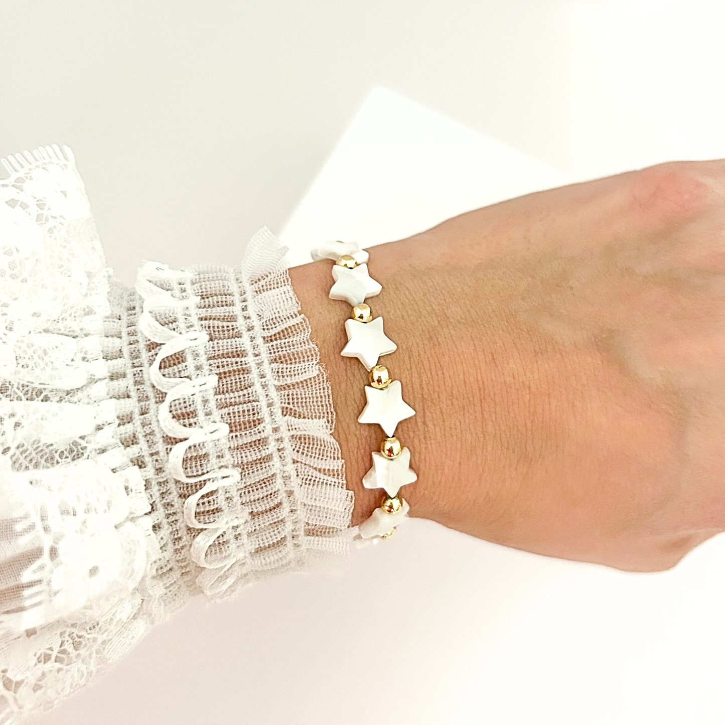 Minimalist star bracelet combining pearly white accents and gold details, perfect for everyday wear or gifting.