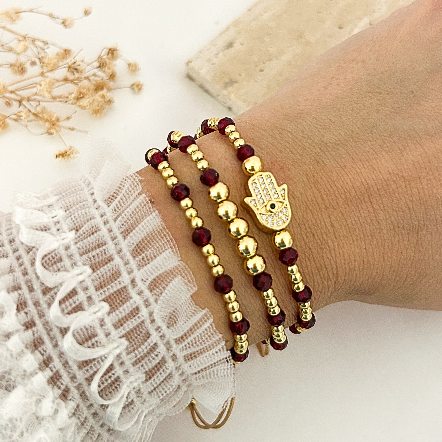 Close-up of Hamsa charm bracelet with garnet-color crystal beads