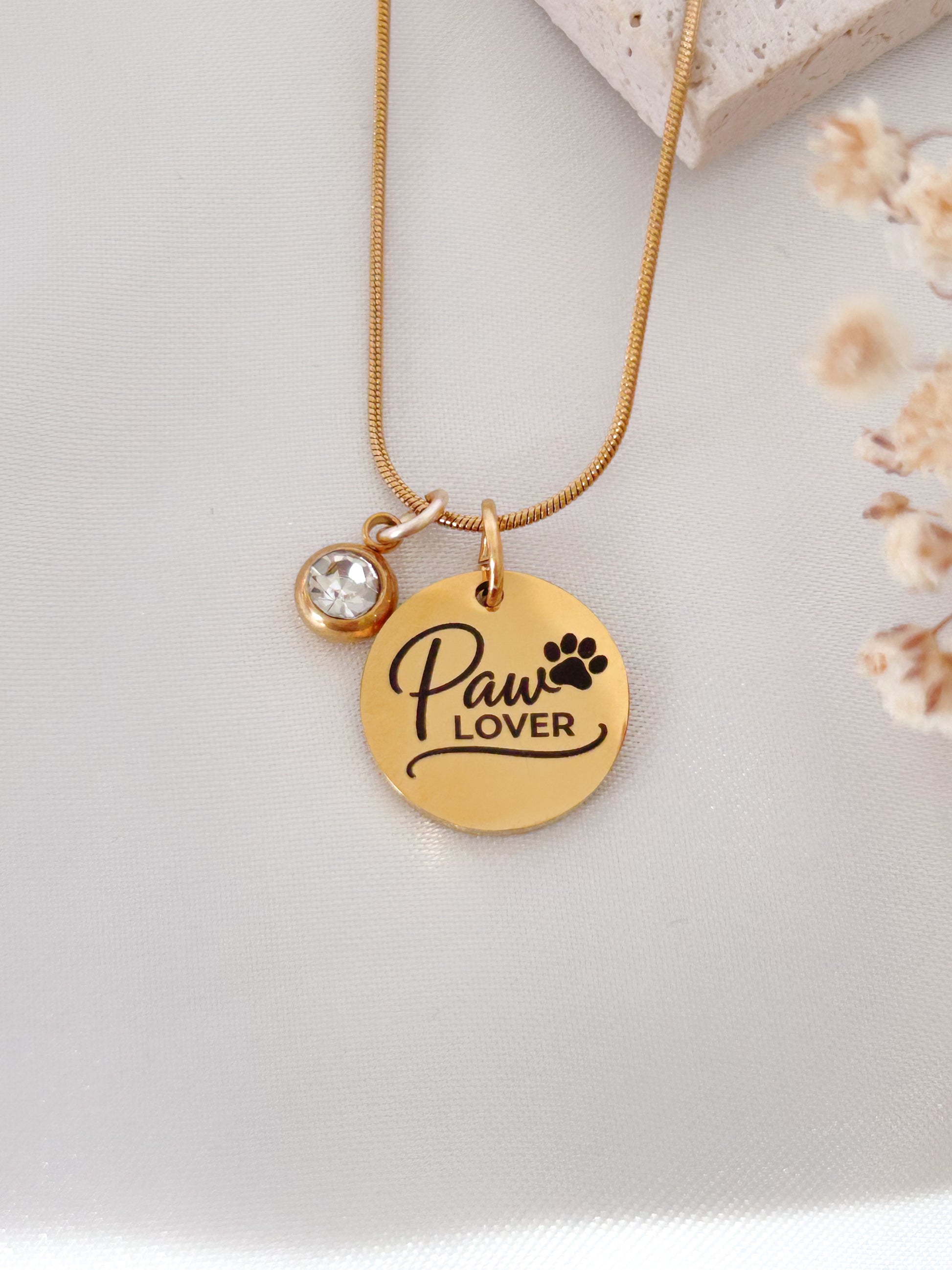 Gold necklace with 'Paw Lover' pendant on a light background
