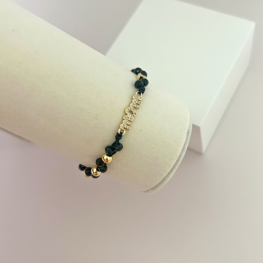 Black crystal bead bracelet with a rhinestone MOM centerpiece displayed on a jewelry stand.