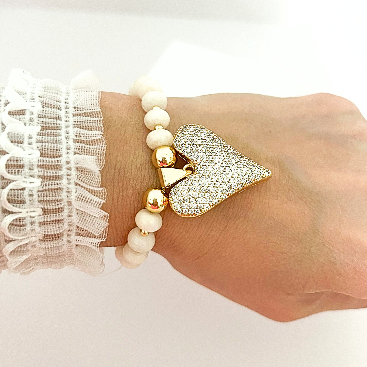 Sophisticated ivory beaded bracelet accented with gold-tone beads and a sparkling heart pendant for a timeless look.