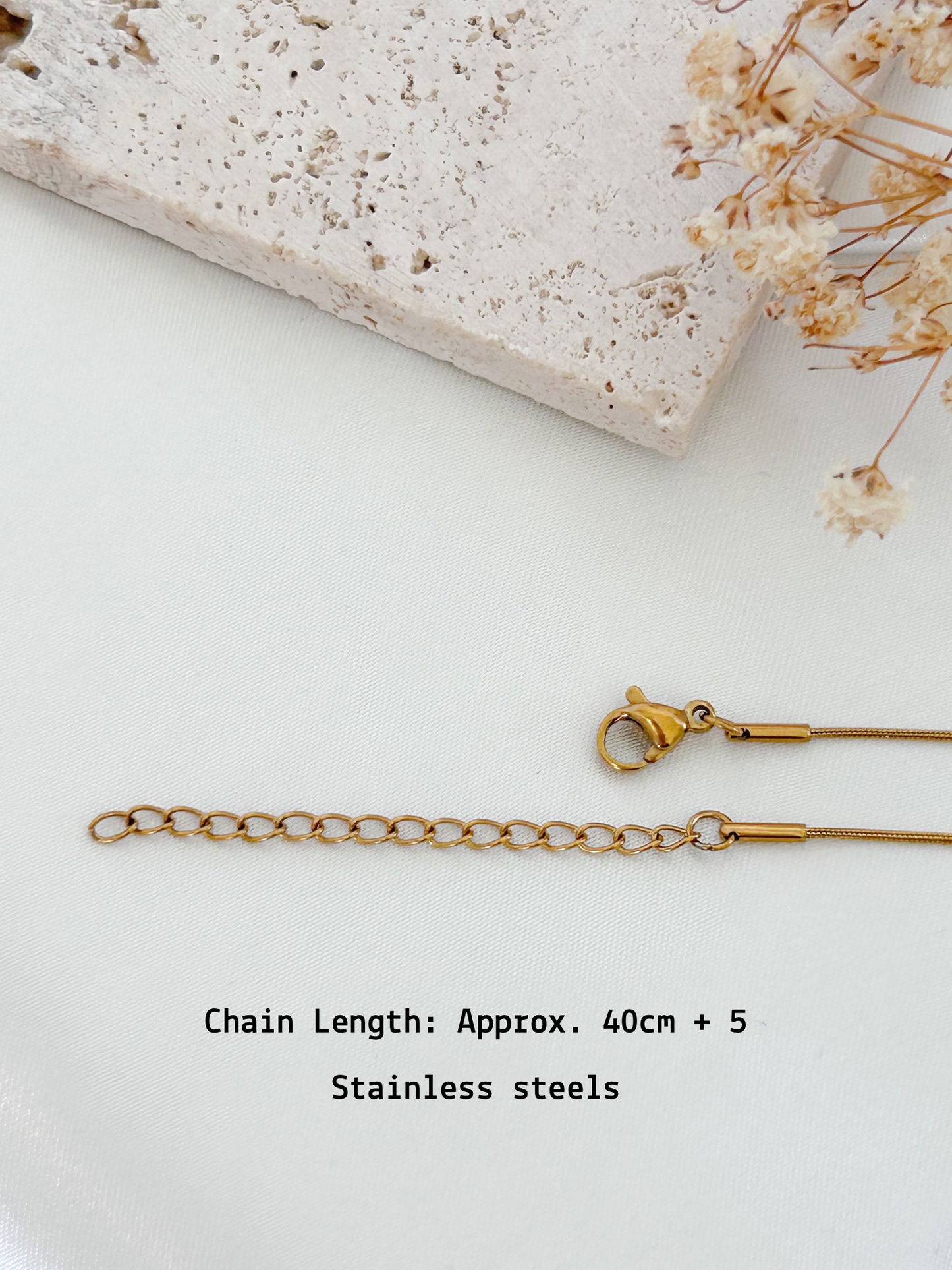 Gold chain necklace on a white surface with text indicating chain length and material.