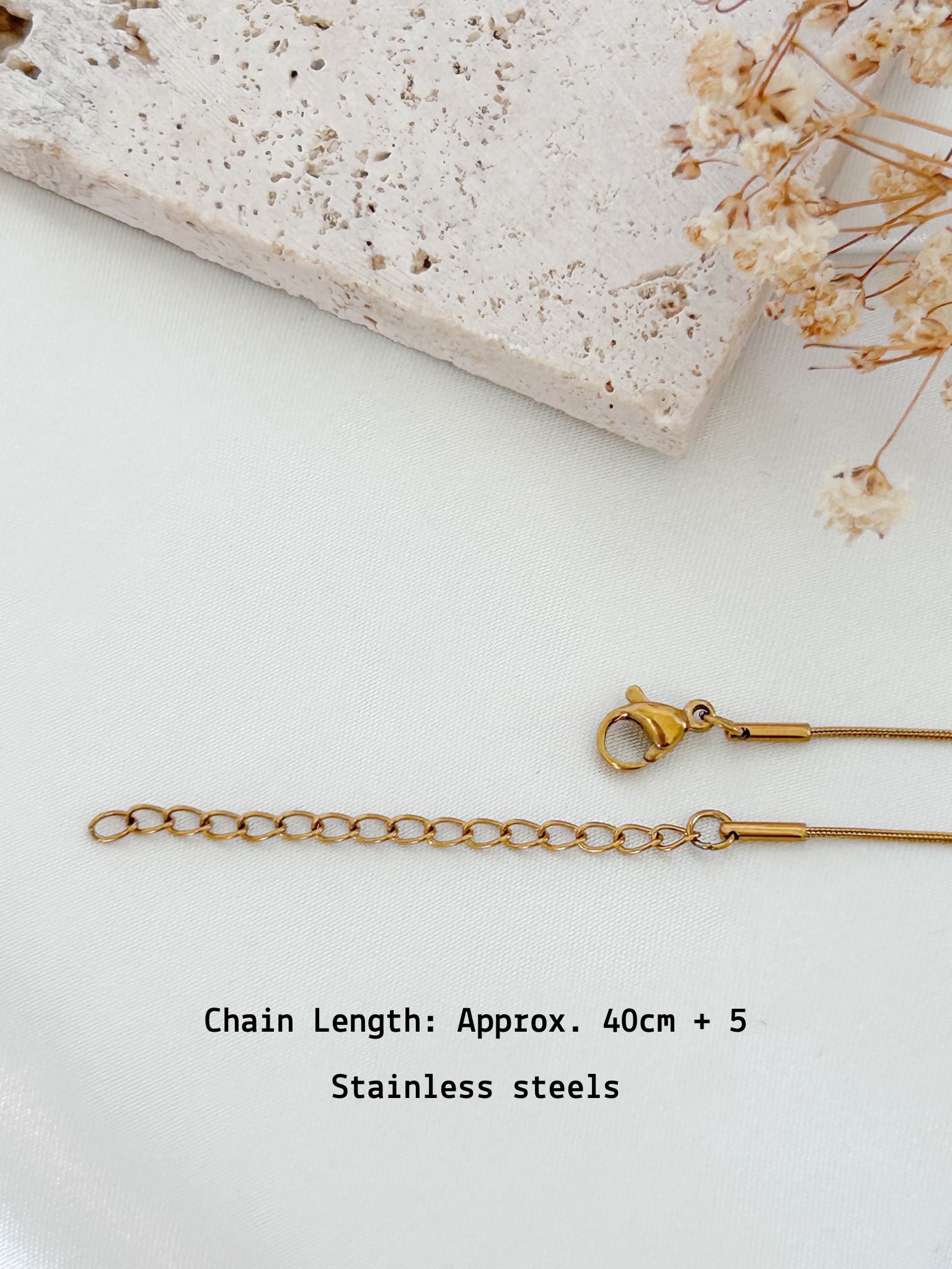 Gold chain necklace on a white surface with text indicating chain length and material.