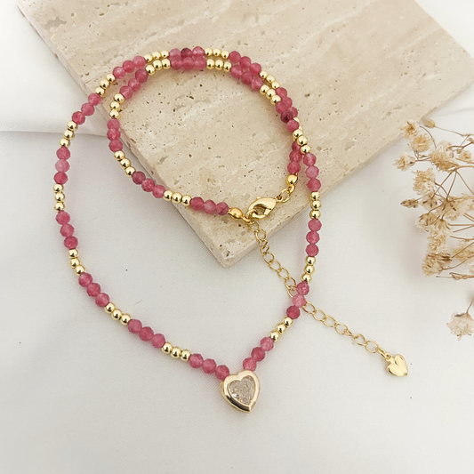 Pink tourmaline beaded choker with druzy heart charm on a stone tray