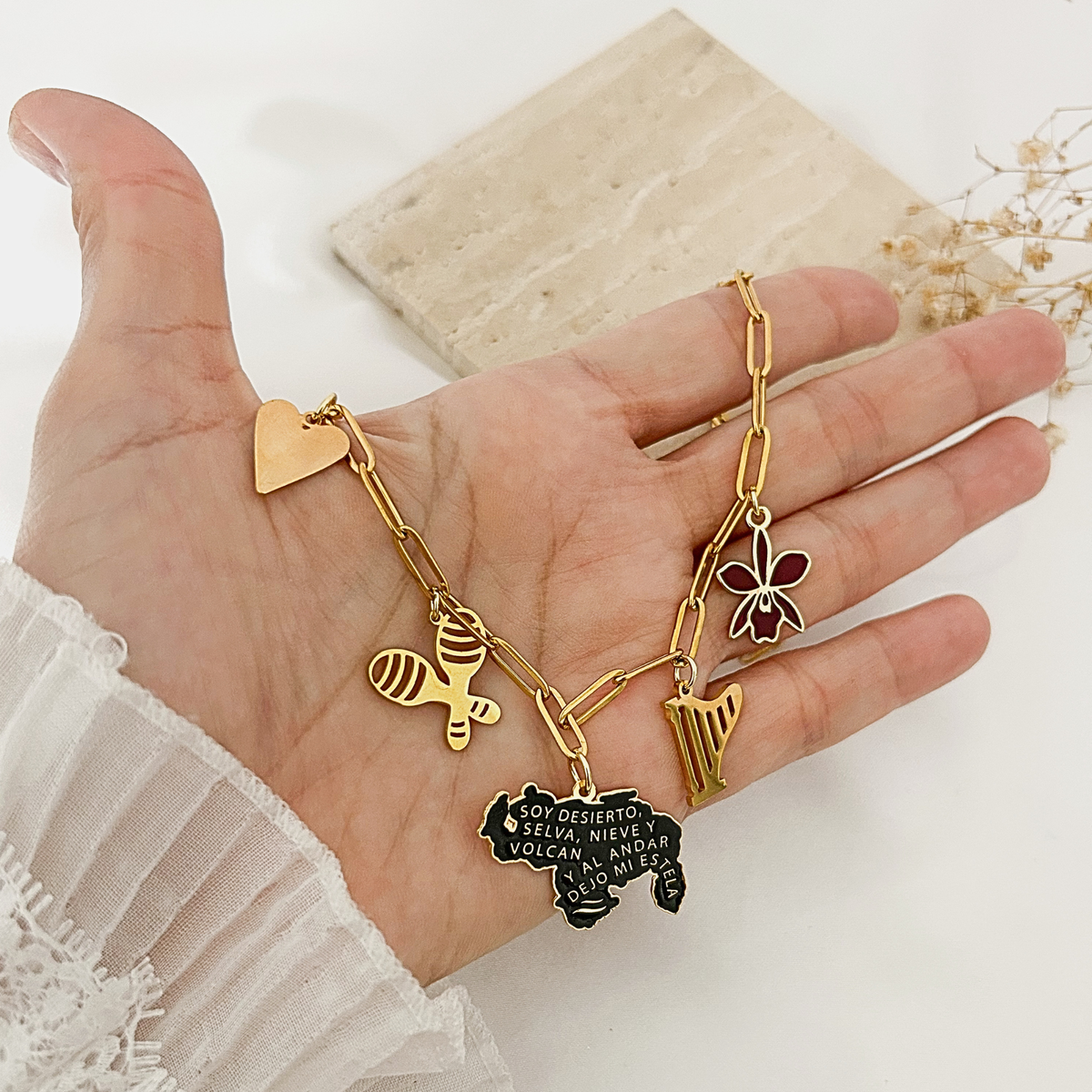 Hand holding Venezuela charm necklace to show size and detail