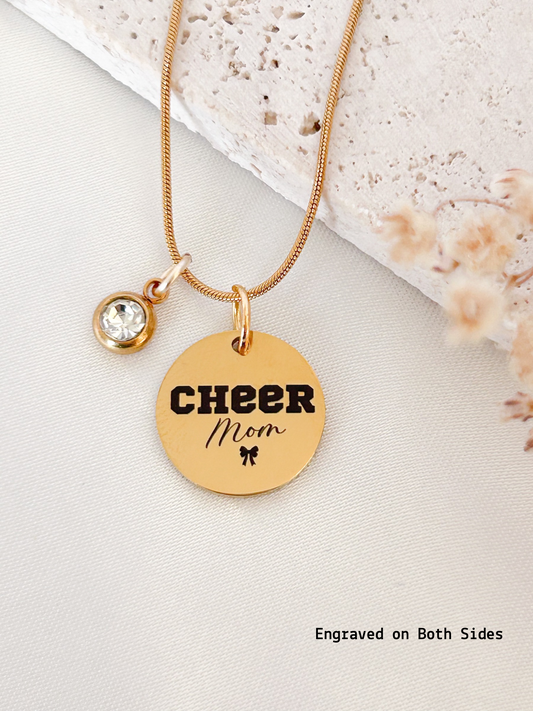 Gold necklace with 'Cheer Mom' pendant on a light background