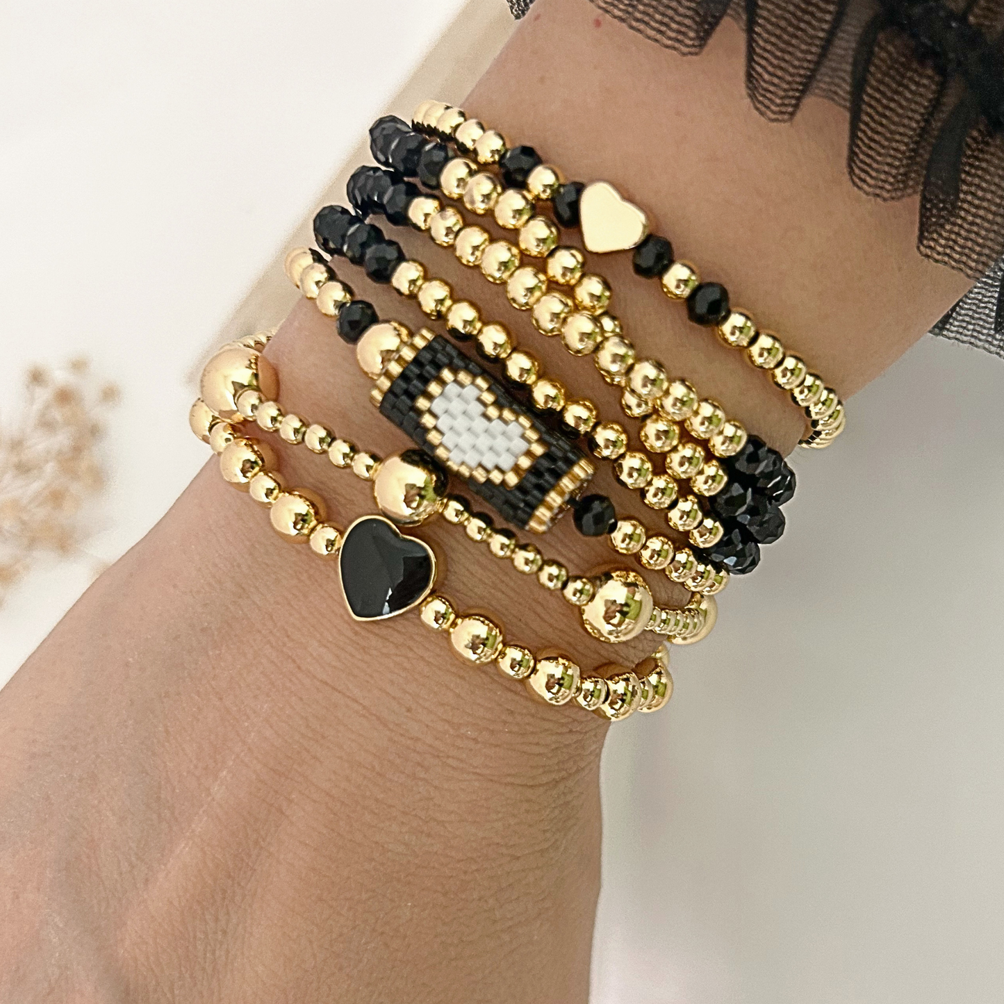 Black gold minimal heart bracelet set with miyuki accent worn on wrist